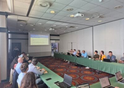 A speaker stands in front of a screen delivering opening remarks to seated Inno2MARE participants during the June 2025 consortium meeting.